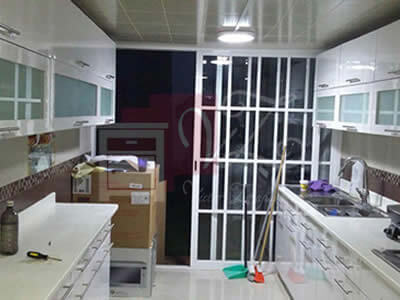 Cocina Integral con cubierta de color blanco con cristalería.